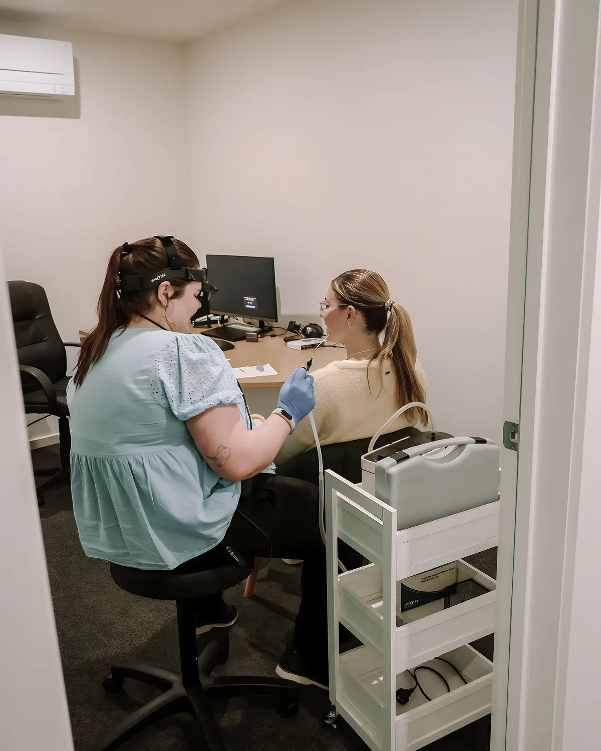 Audiologist carrying out micro-suction wax removal in the treatment room at Lakes Audiology